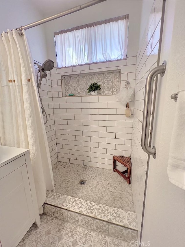 bathroom with a stall shower and tile patterned flooring