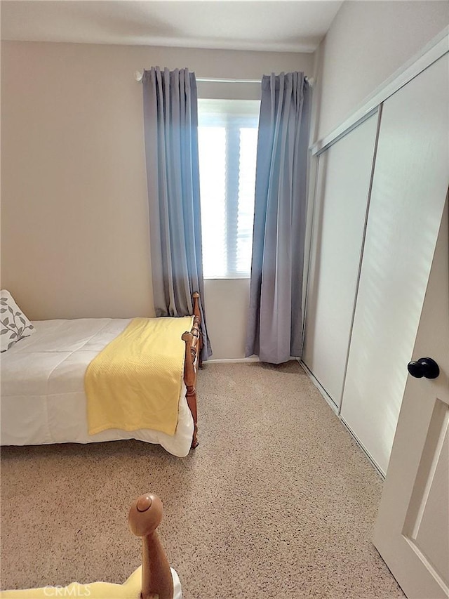 bedroom featuring speckled floor and a closet