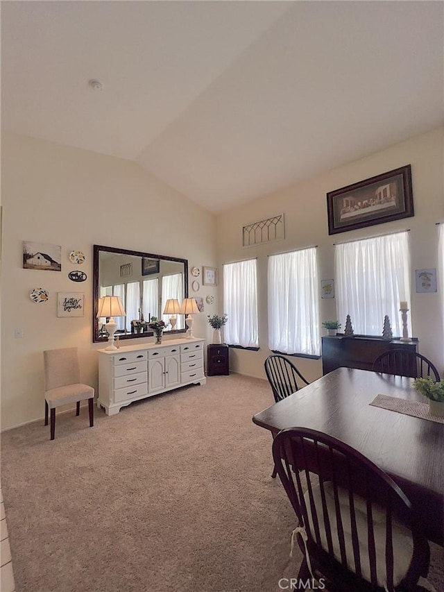 dining room featuring vaulted ceiling, carpet, and a wealth of natural light