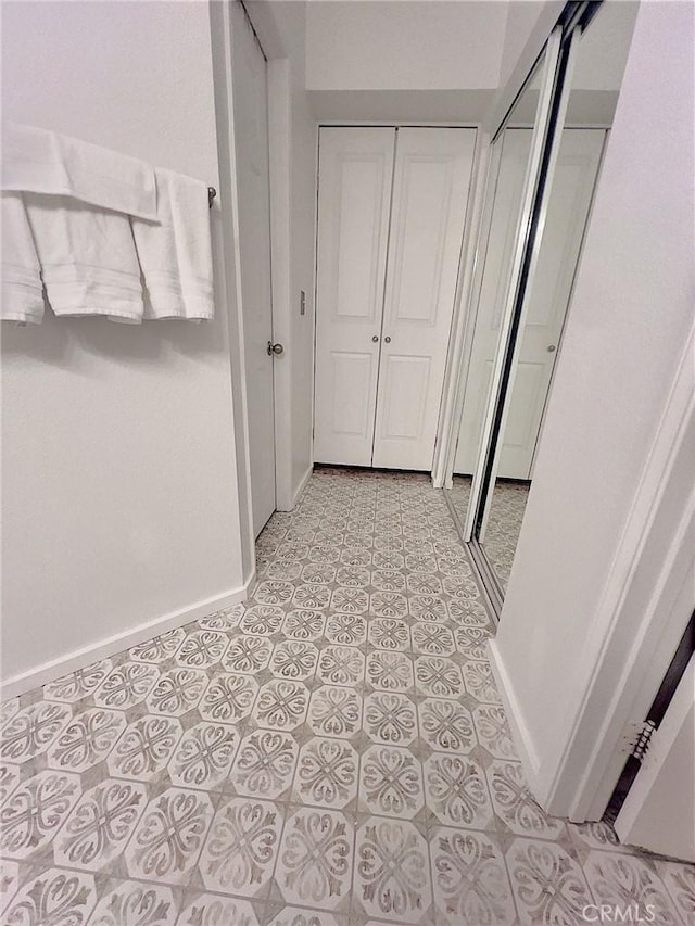 hallway featuring light tile patterned floors and baseboards