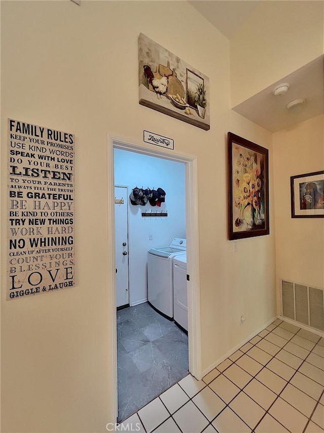 corridor with separate washer and dryer, a towering ceiling, and visible vents