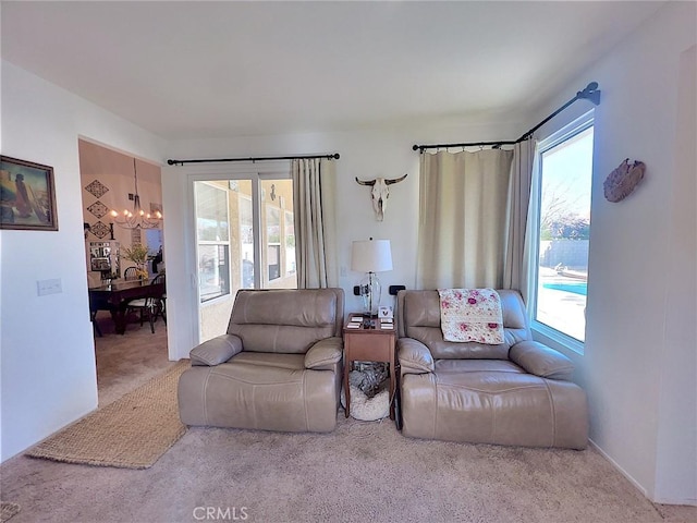 carpeted living area with a notable chandelier