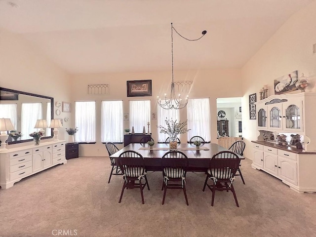 dining room with a chandelier and light colored carpet