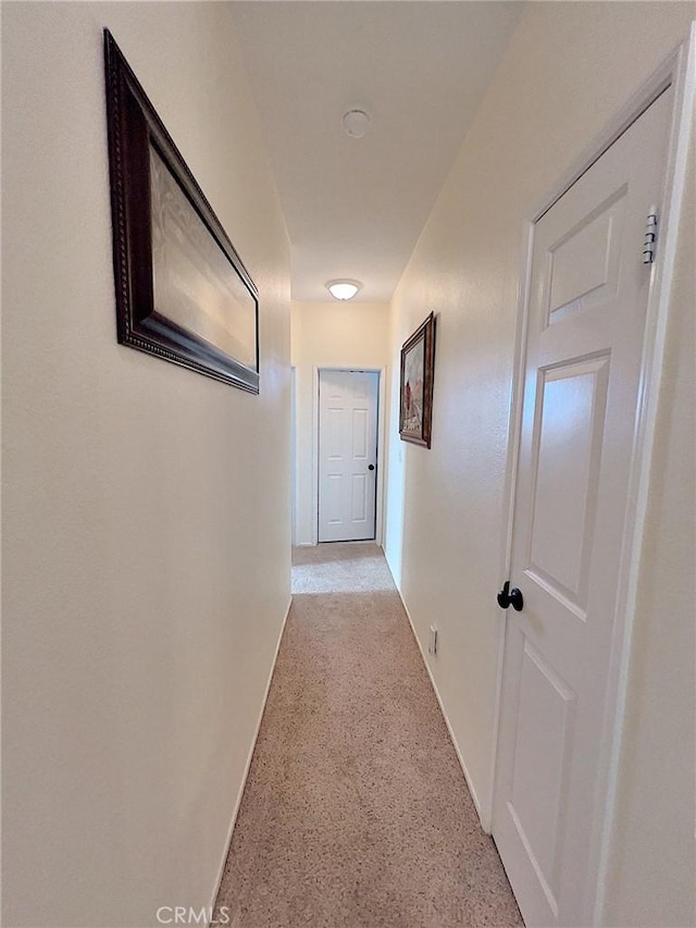 corridor featuring baseboards and speckled floor