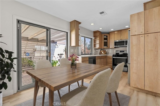 dining room with light wood-style floors, recessed lighting, and visible vents