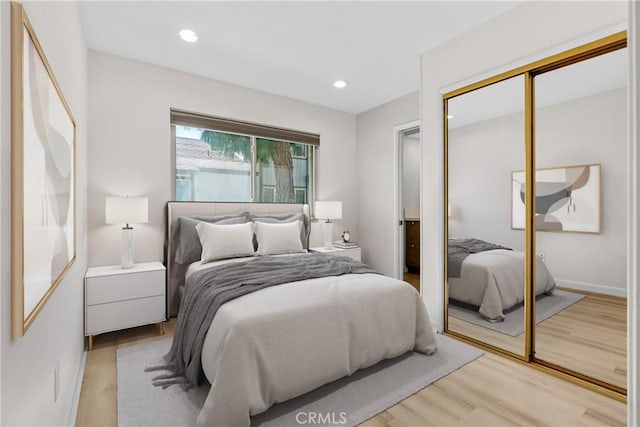 bedroom featuring baseboards, a closet, recessed lighting, and light wood-style floors