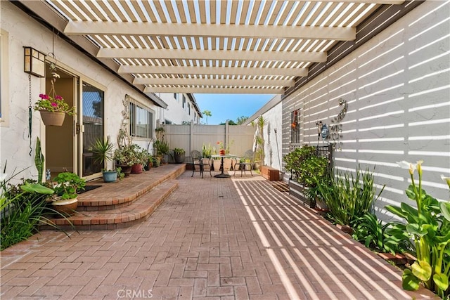 view of patio featuring outdoor dining space, fence, and a pergola