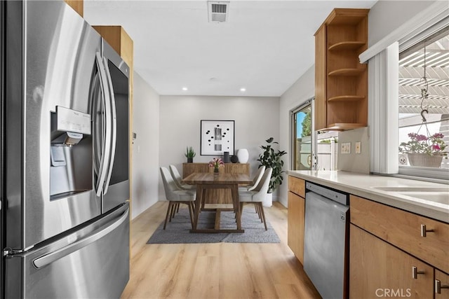 kitchen featuring open shelves, light countertops, visible vents, light wood-style flooring, and appliances with stainless steel finishes