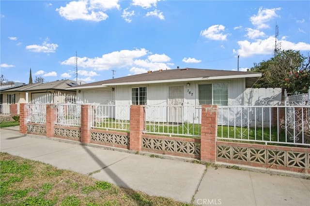 ranch-style house with concrete driveway and a fenced front yard