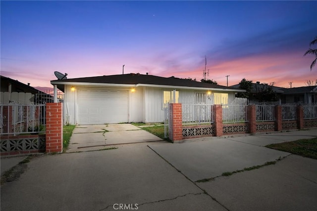 view of front of home with driveway, a fenced front yard, and a garage