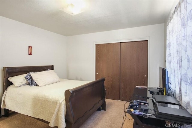 bedroom with light carpet and a closet