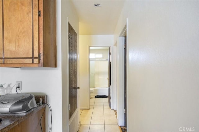 hall with light tile patterned floors and visible vents