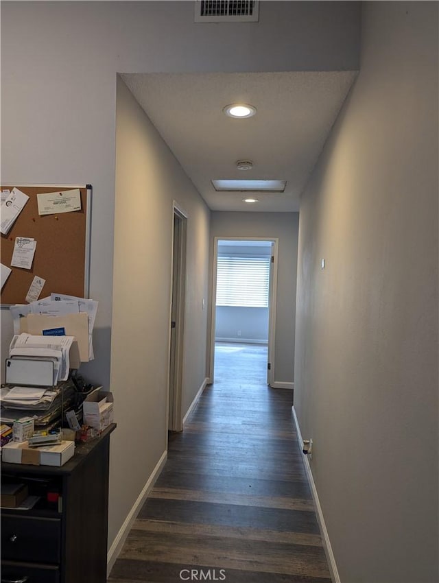 hall with baseboards, visible vents, dark wood-style flooring, and recessed lighting