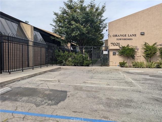 uncovered parking lot featuring fence