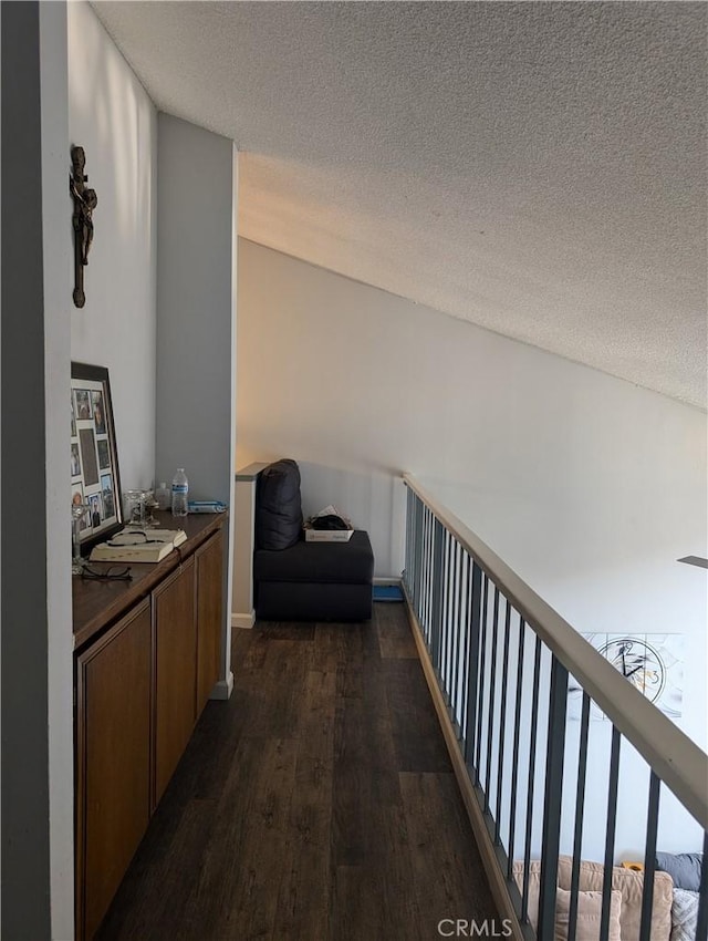 corridor featuring dark wood finished floors and a textured ceiling