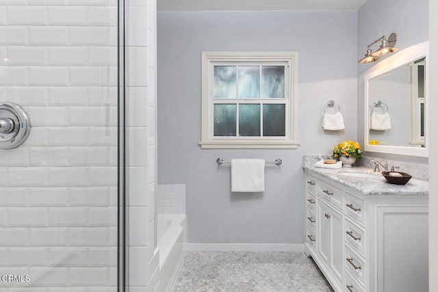 bathroom featuring tiled shower, vanity, baseboards, and a bath