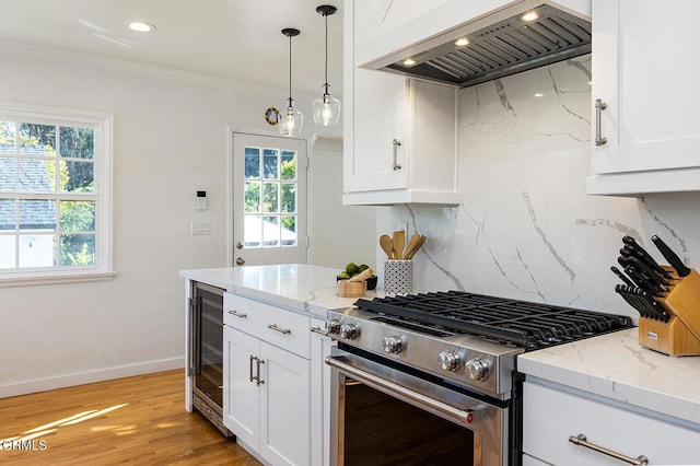 kitchen featuring ornamental molding, gas stove, white cabinets, and custom exhaust hood