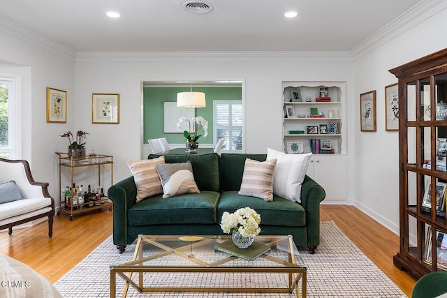 living area featuring light wood-style floors, a wealth of natural light, and visible vents