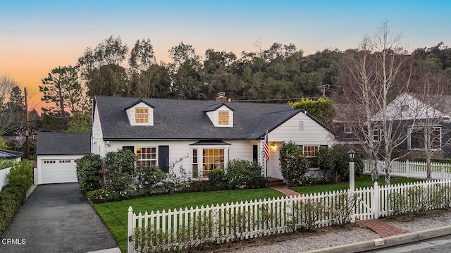 cape cod house featuring a garage, a fenced front yard, a chimney, an outdoor structure, and a front lawn