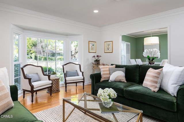 living room with baseboards, ornamental molding, light wood-type flooring, and recessed lighting