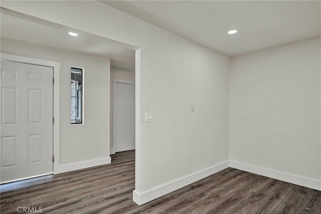 spare room with recessed lighting, dark wood finished floors, and baseboards