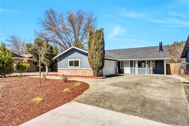 single story home with a garage, brick siding, a shingled roof, fence, and concrete driveway