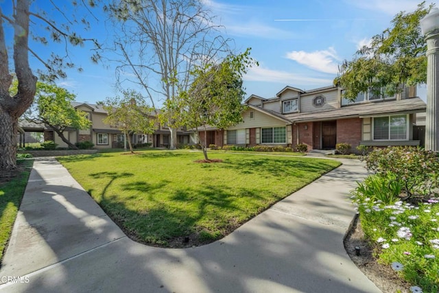 view of front of property with a front lawn and brick siding