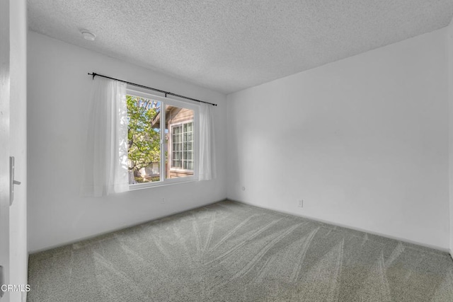 unfurnished room featuring carpet flooring and a textured ceiling