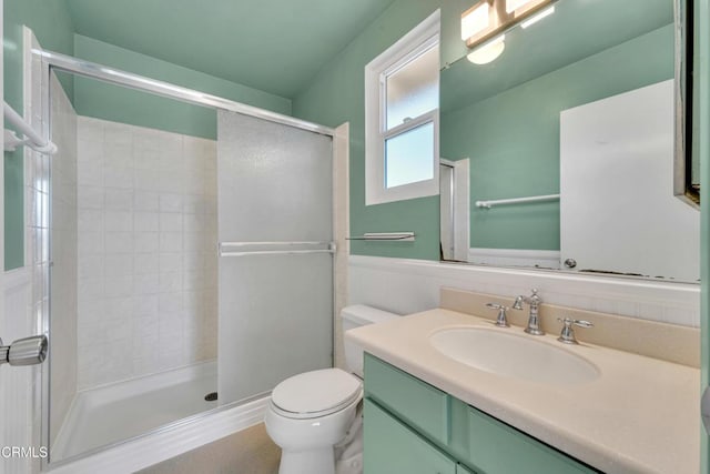 bathroom featuring a stall shower, vanity, and toilet