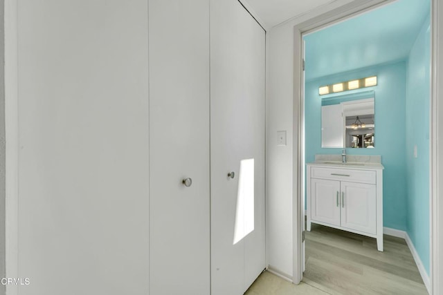 interior space featuring wood finished floors, vanity, and baseboards