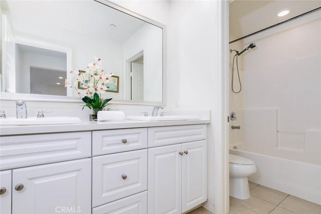 full bath with double vanity, toilet,  shower combination, tile patterned flooring, and a sink