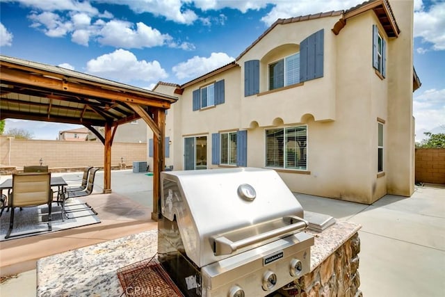 back of house with a patio area, fence, an outdoor kitchen, and stucco siding