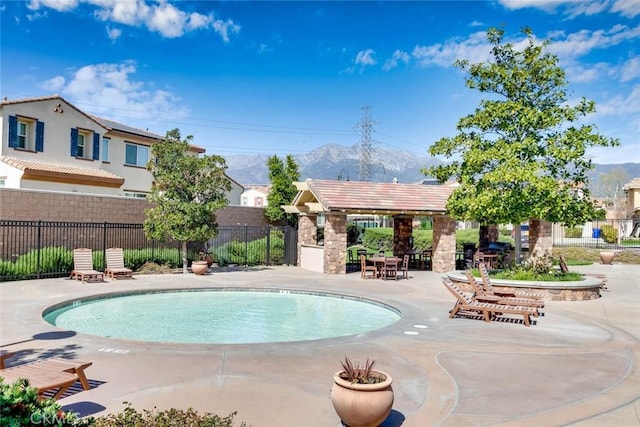 community pool with a patio area and fence