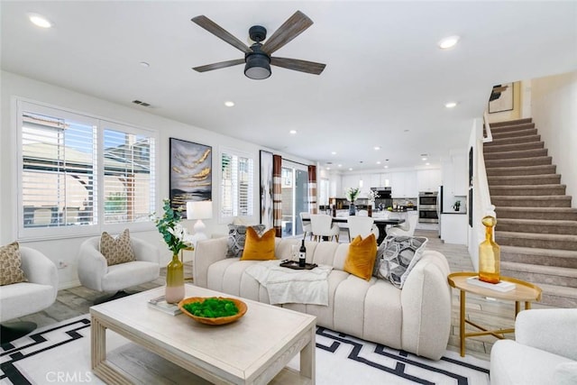 living room featuring recessed lighting, visible vents, ceiling fan, and stairway