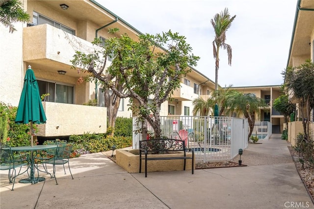 view of property's community with fence and a patio