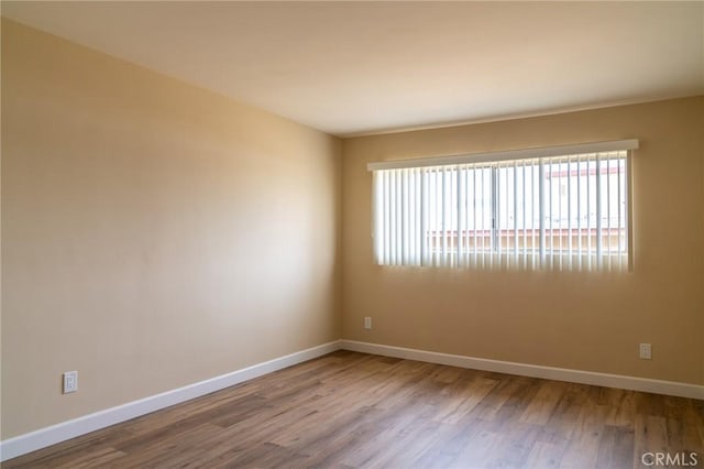 spare room with wood finished floors and baseboards