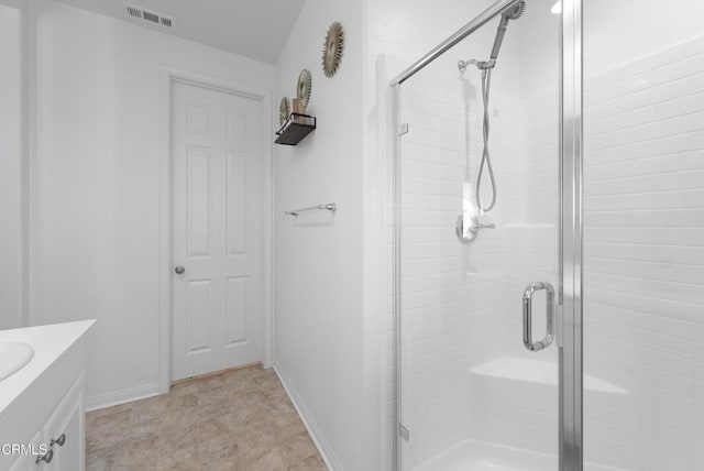 full bath with a stall shower, visible vents, vanity, and baseboards