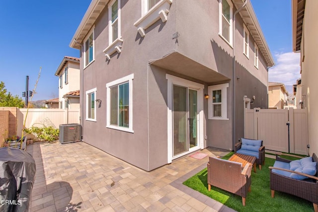 back of house with a patio area, a fenced backyard, an outdoor living space, and stucco siding