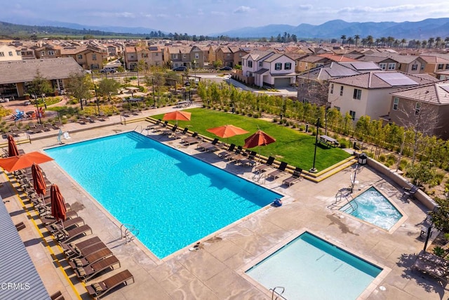 community pool with a residential view, fence, a mountain view, and a patio