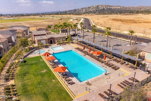 pool with a patio area and fence