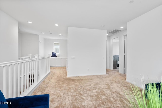 empty room featuring light carpet, baseboards, and recessed lighting