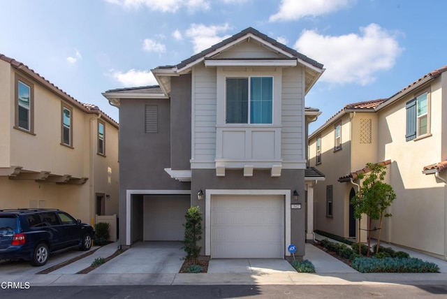 view of front of home featuring concrete driveway, an attached garage, and stucco siding