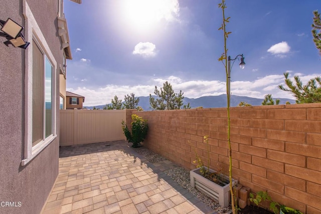 view of patio with a fenced backyard and a mountain view