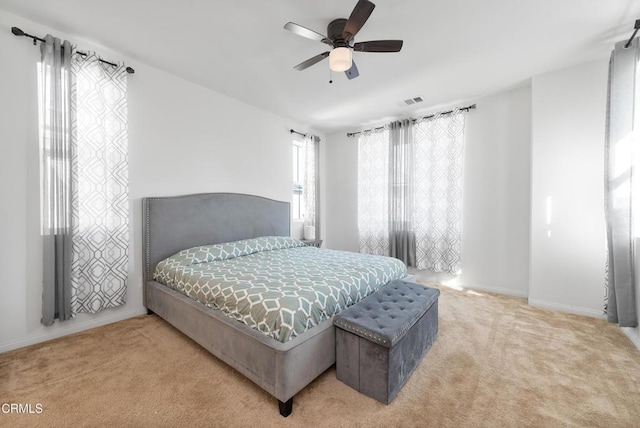 carpeted bedroom featuring baseboards, visible vents, and ceiling fan