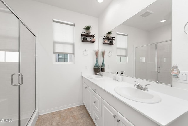 full bath featuring a sink, a shower stall, and double vanity