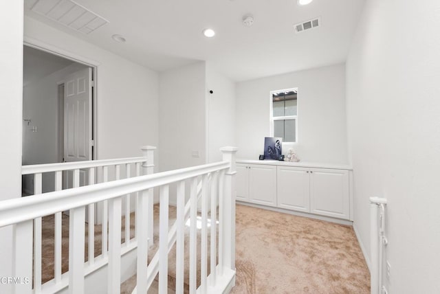 corridor featuring recessed lighting, radiator, light colored carpet, visible vents, and an upstairs landing