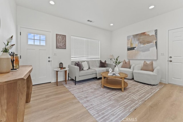 living area with light wood-type flooring, visible vents, and recessed lighting