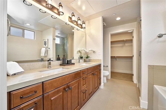 bathroom featuring double vanity, a stall shower, tile patterned flooring, and a sink