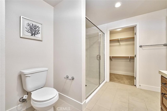 full bathroom featuring a stall shower, vanity, baseboards, and tile patterned floors