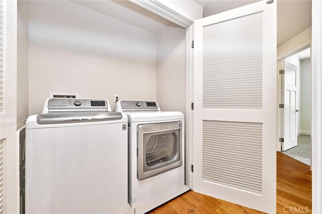 laundry area with light wood-type flooring, laundry area, and independent washer and dryer